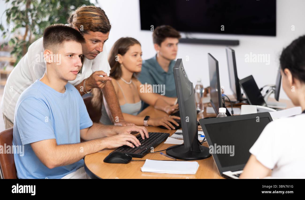 Male instructor assisting motivated guy during computer course Stock ...