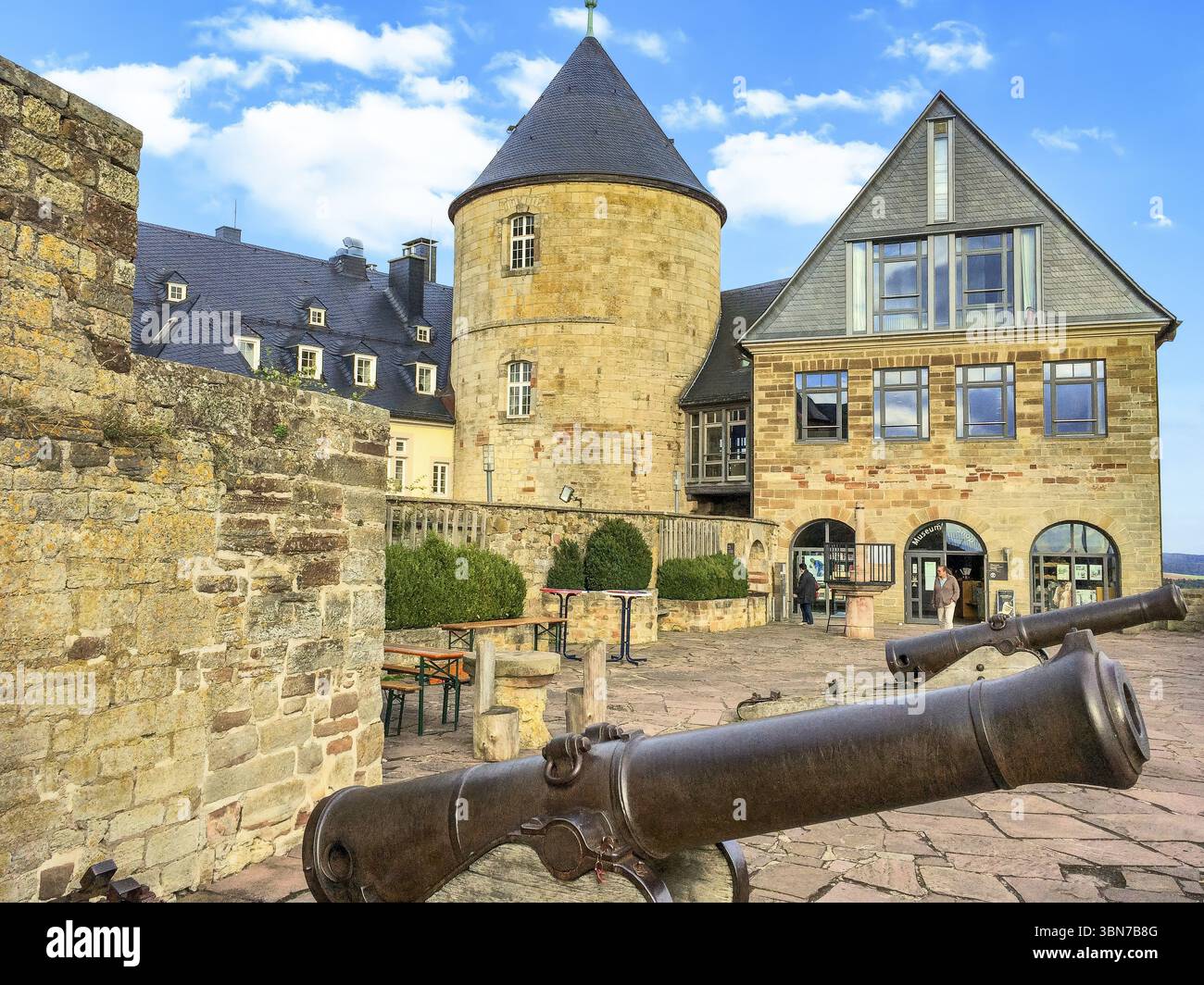 Historic cannons on the viewing terrace of Waldeck Castle former aristocratic residence of the Counts of Waldeck in Ederbergland, in the background on Stock Photo