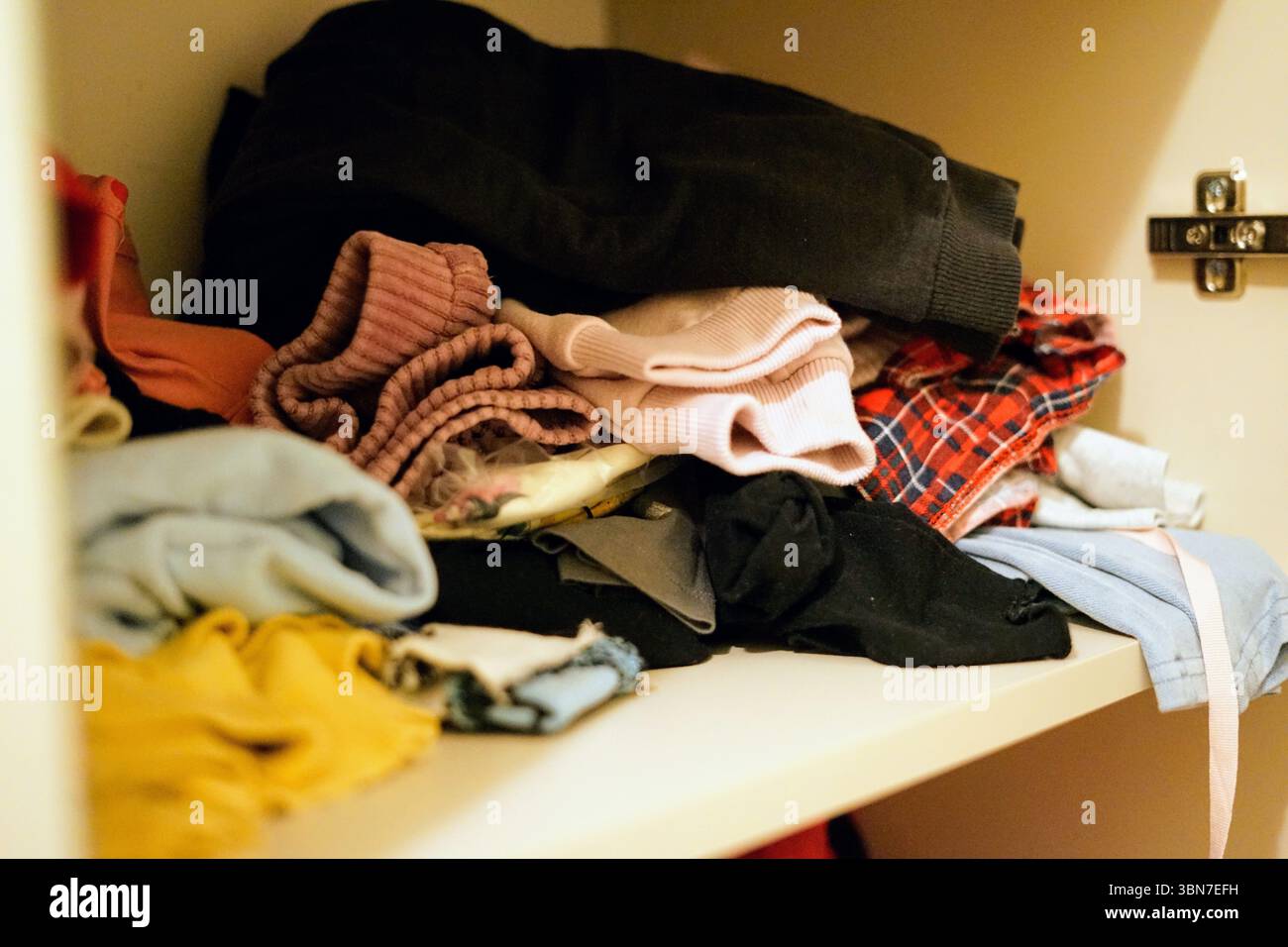 clothes in the shelf in mess pile organisation stack folded cleanliness ...