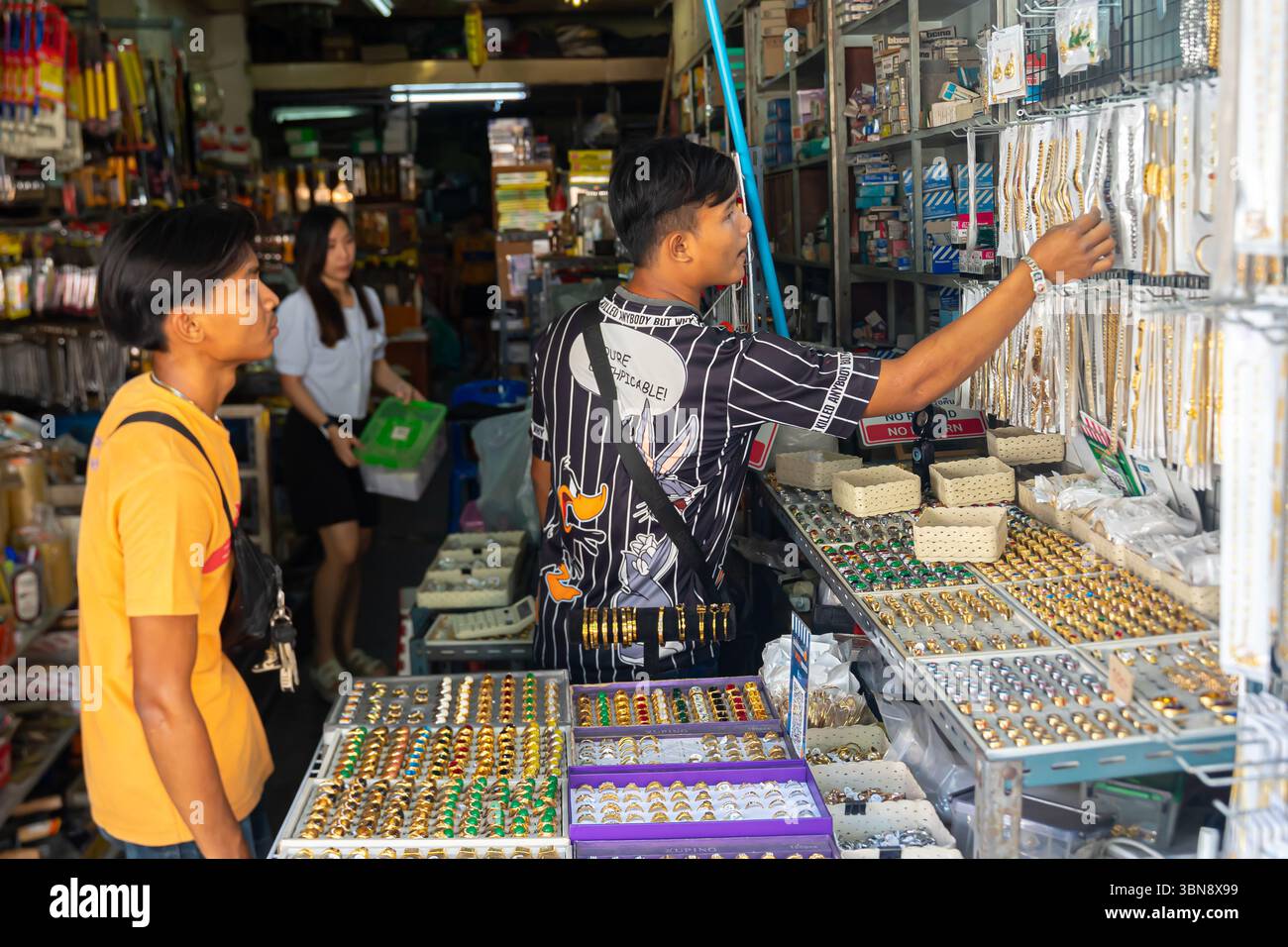 Shoppers are browsing jewelry at a street-side stall. Amulet Market,  Phra Borom Maha Ratchawang, Phra Nakhon, Bangkok, Thailand Stock Photo