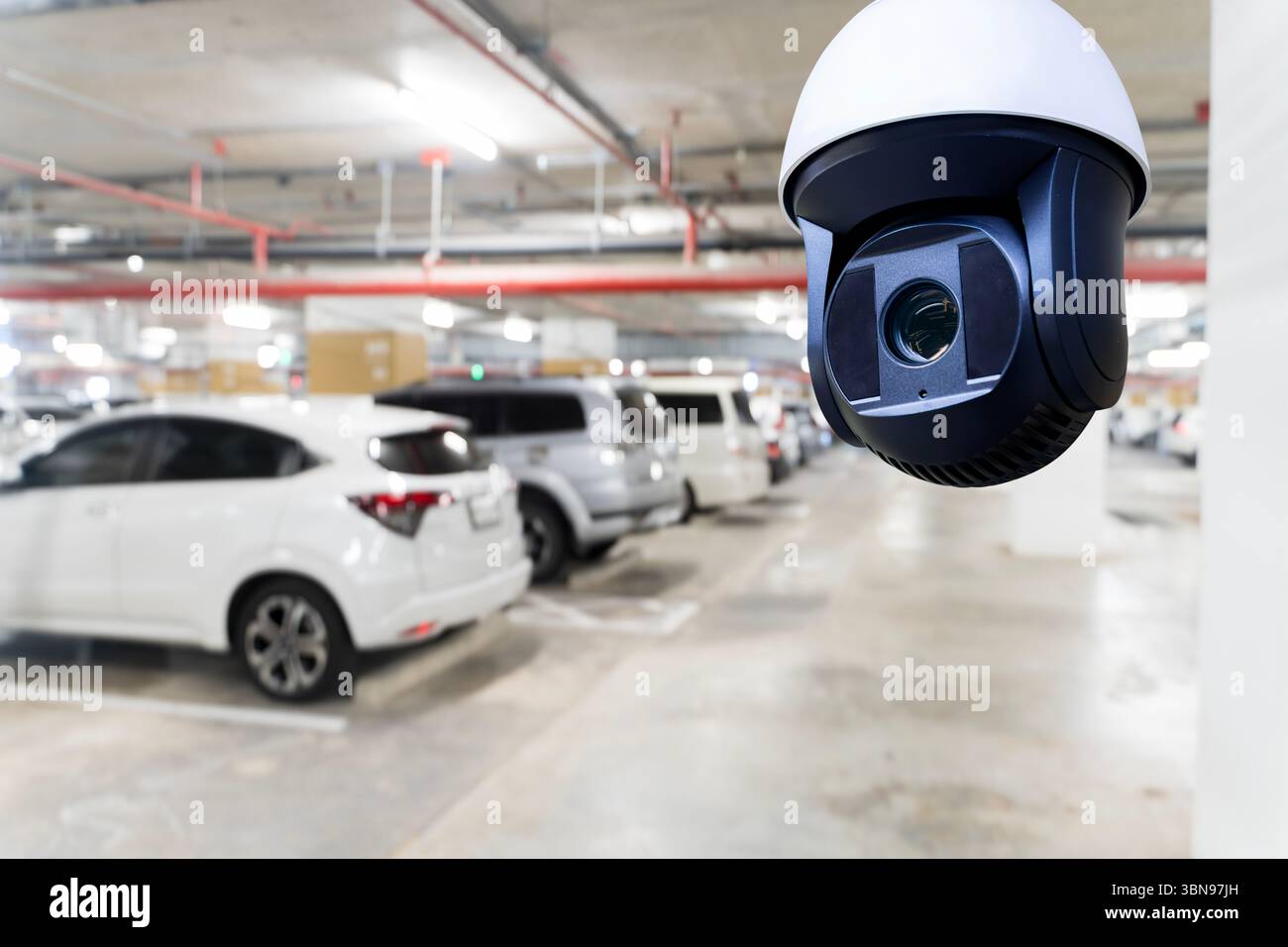 Security CCTV camera recording footage of vehicles in indoor parking ...