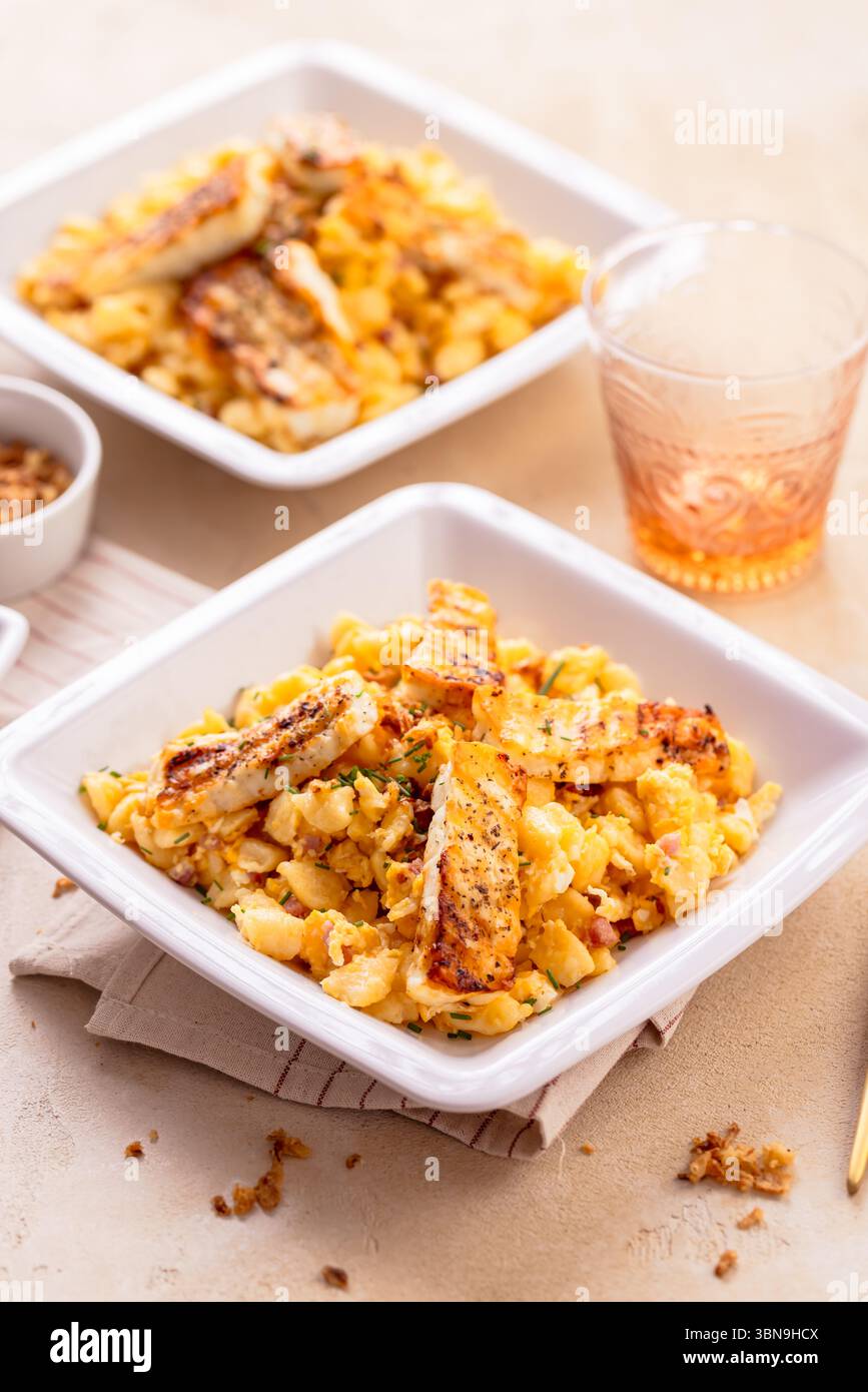 German egg dumplings with bacon, fried onions and grilled Halloumi cheese Stock Photo