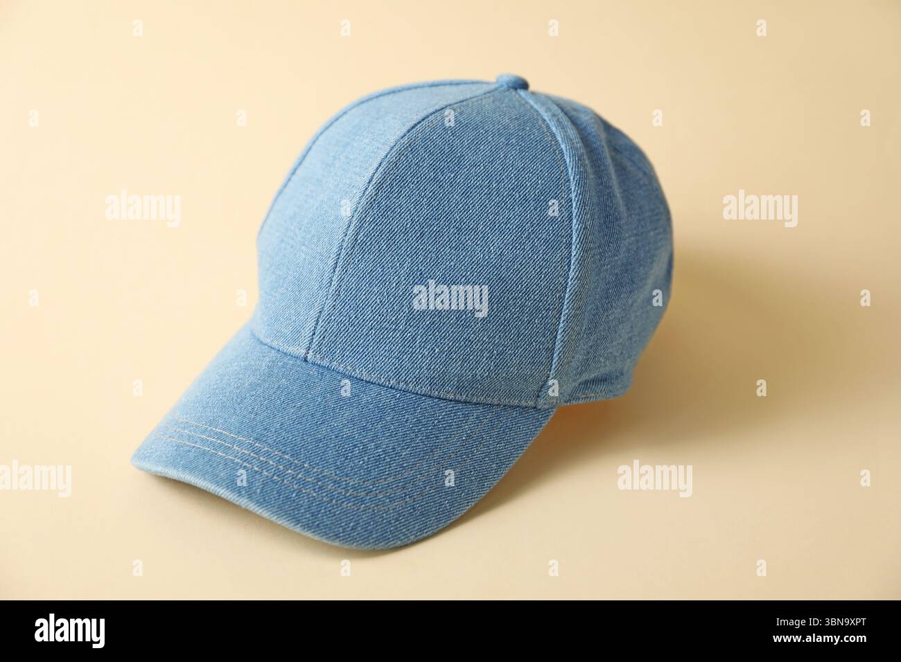 Denim baseball hat on beige background, closeup Stock Photo