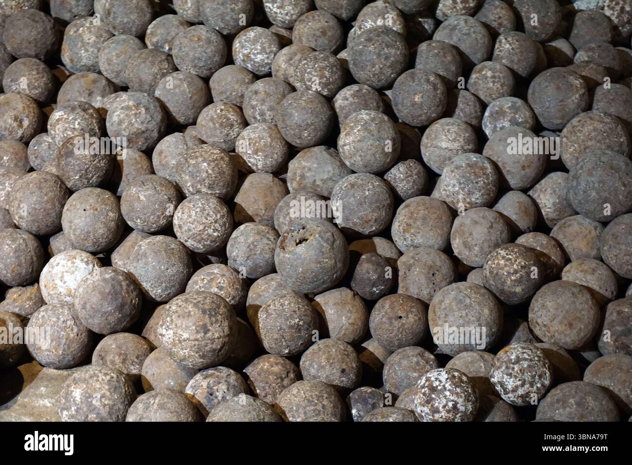 Spherical Rust Buildup A large pile of old, weathered, and worn spheres, likely made of metal ...