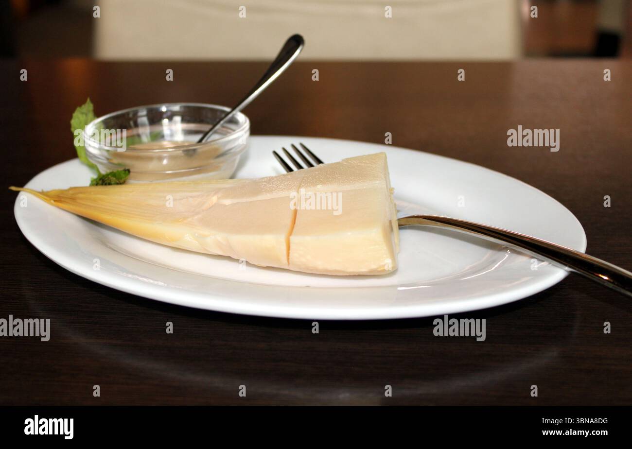 A plate of fresh green bamboo with accompanying sauce. Stock Photo