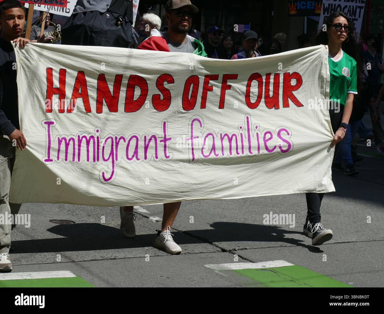 Seattle — June 14, 2025 — Protesters carry a banner reading ‘Hands off our immigrant families ...’