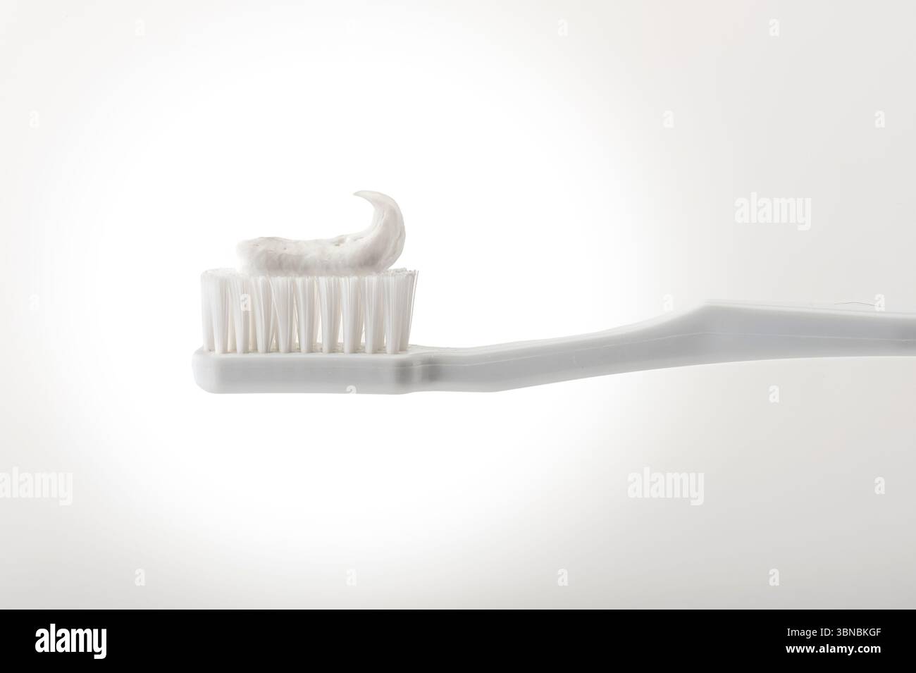 White toothbrush with toothpaste, white background, USA Stock Photo