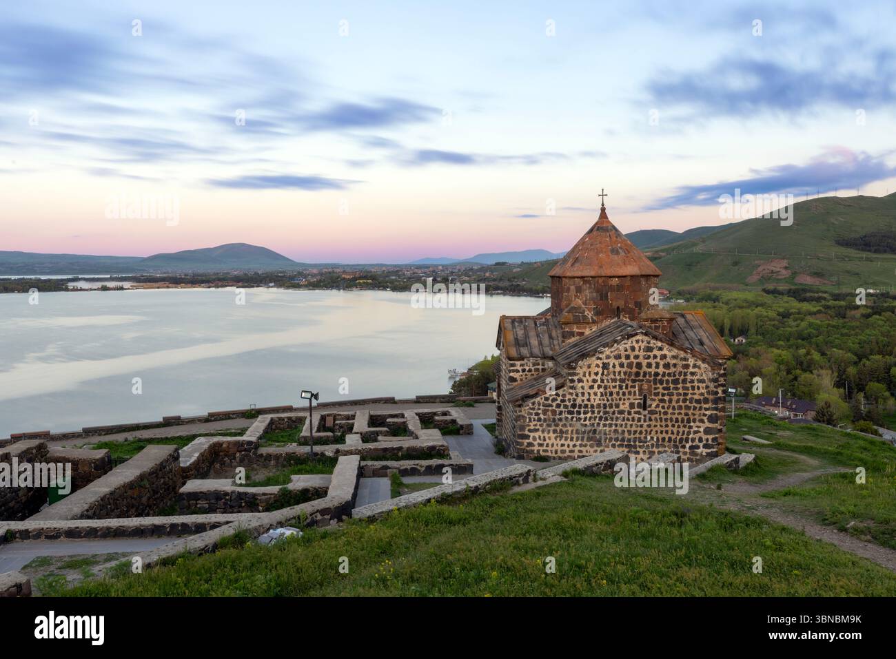 The 9th-century Sevanavank monastery complex, featuring the Surp Arakelots and Surp Astvatsatsin churches, overlooks the expansive blue waters of Lake Stock Photo