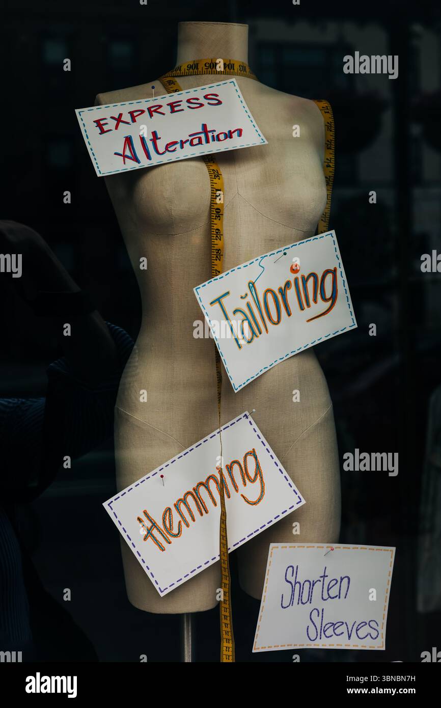 Mannequin Signs A mannequin stands in a store window featuring signs for tailoring ...