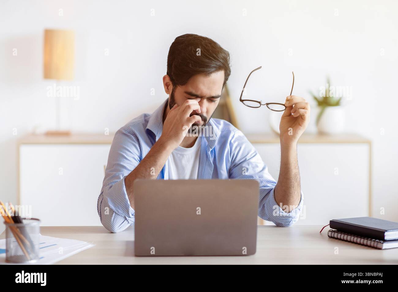 Eye Strain. Tired Arab Freelancer Guy Feeling Exhausted After Working On Laptop Stock Photo