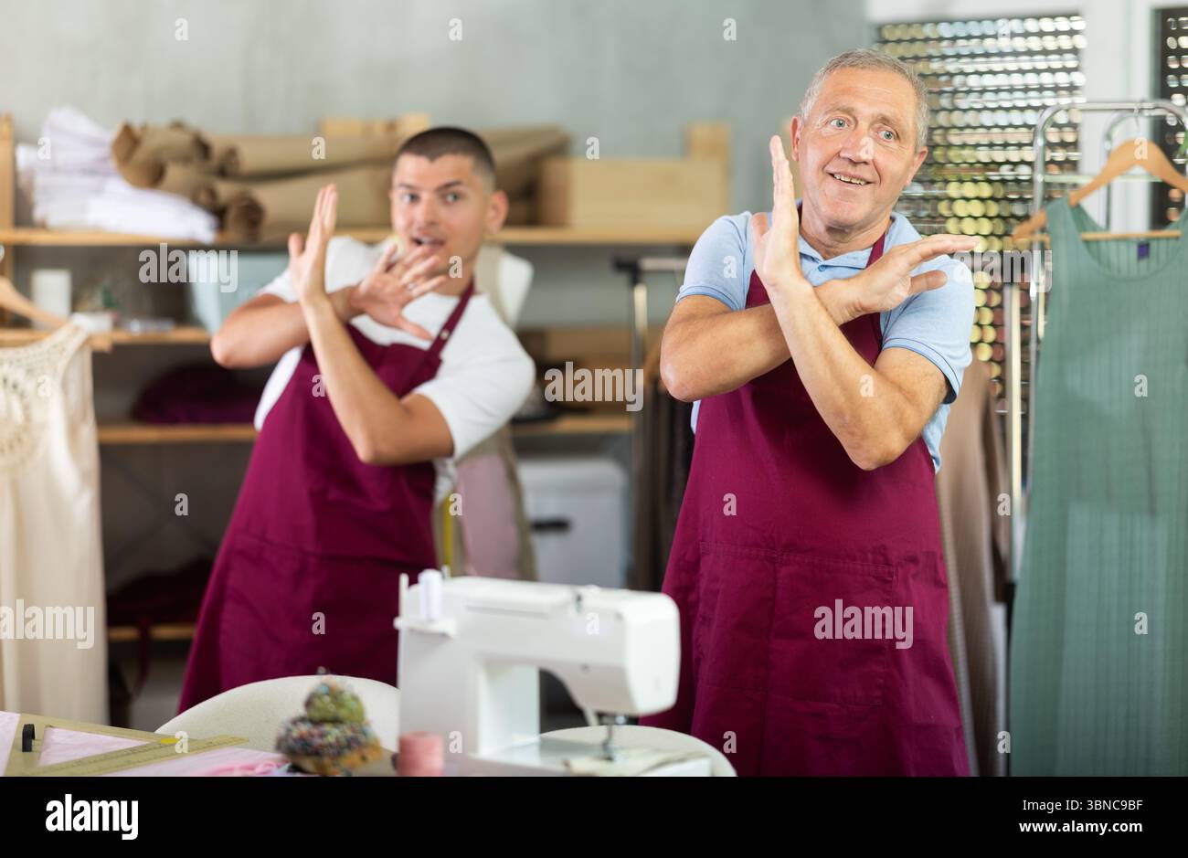 Male tailors doing a warm-up at work Stock Photo