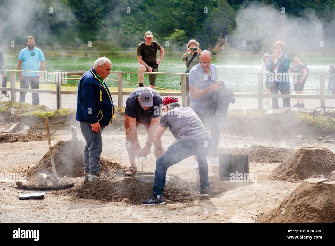 Tourists removing pots of cozido das Furnas, traditional meat stew dish cooked on volcanic soil fumaroles, Lagoa das Furnas, Sao Miguel Island, Azores Stock Photo