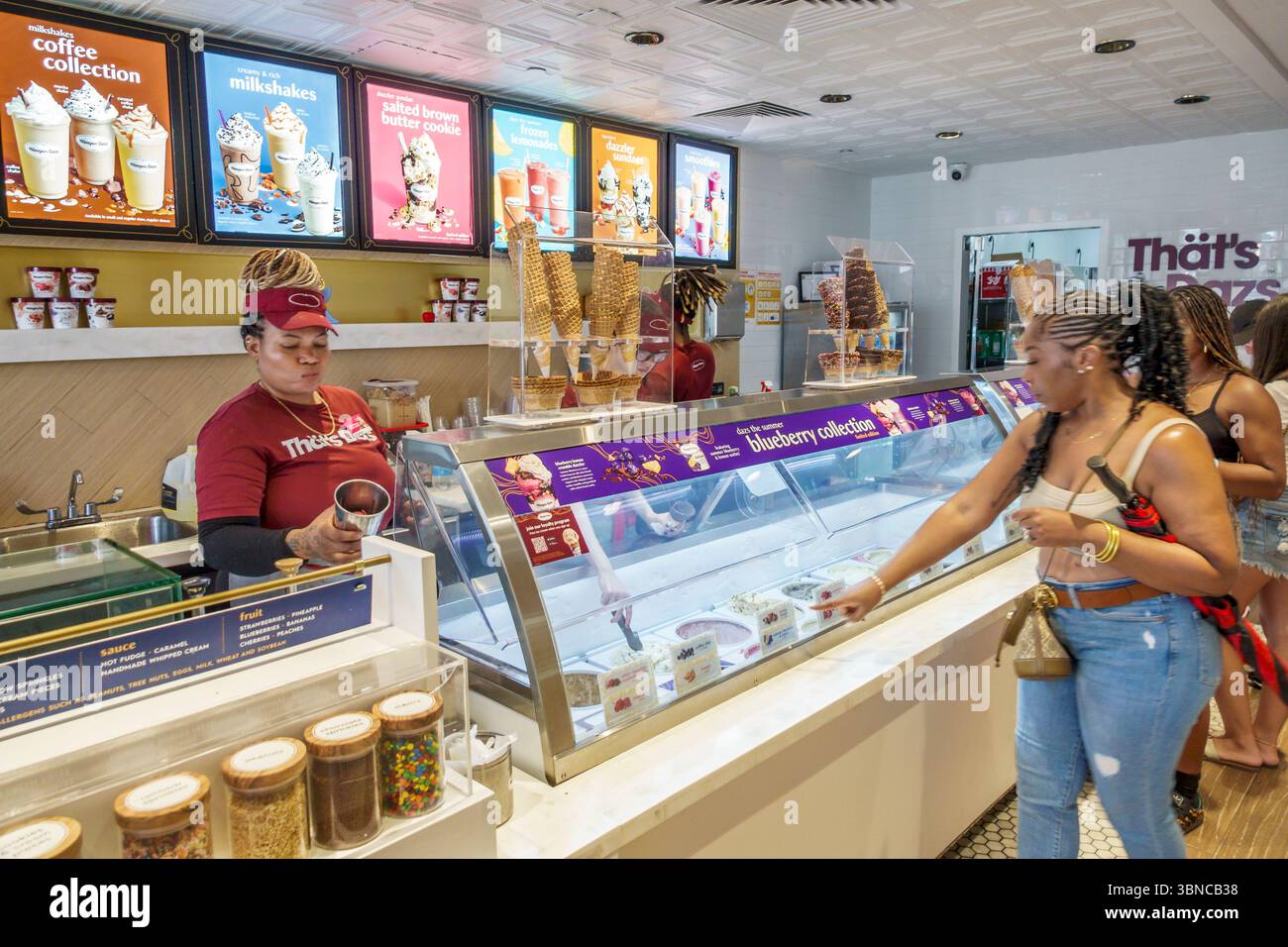 Miami Beach Florida,Lincoln Road pedestrian shopping mall,Haagen Dazs ice cream brand store,inside interior,Black women adult female customers,pointin Stock Photo