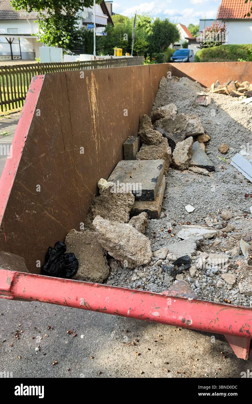 A filled waste container showcases a variety of construction debris ...