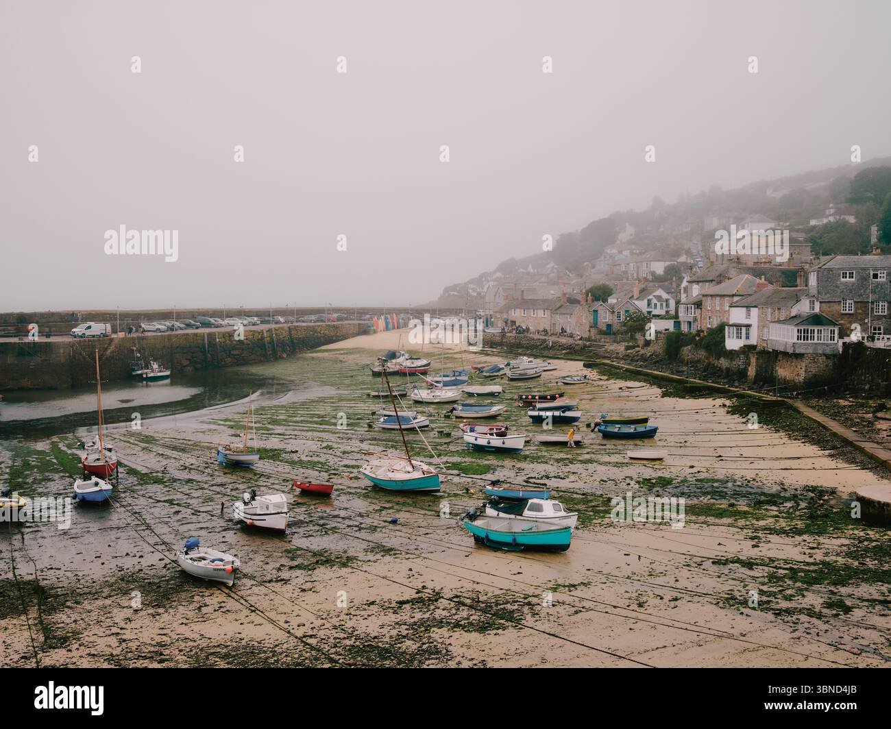 Mousehole village and fishing port in Cornwall, England, UK - cloudy wet weather Stock Photo