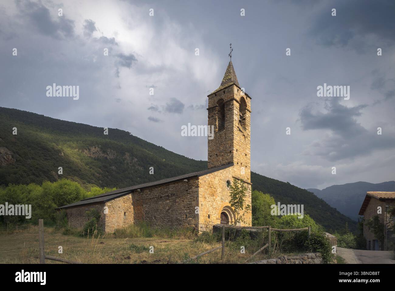 Santa Coloma Church in Catalonia features stunning Romanesque architecture set against dramatic skies Stock Photo