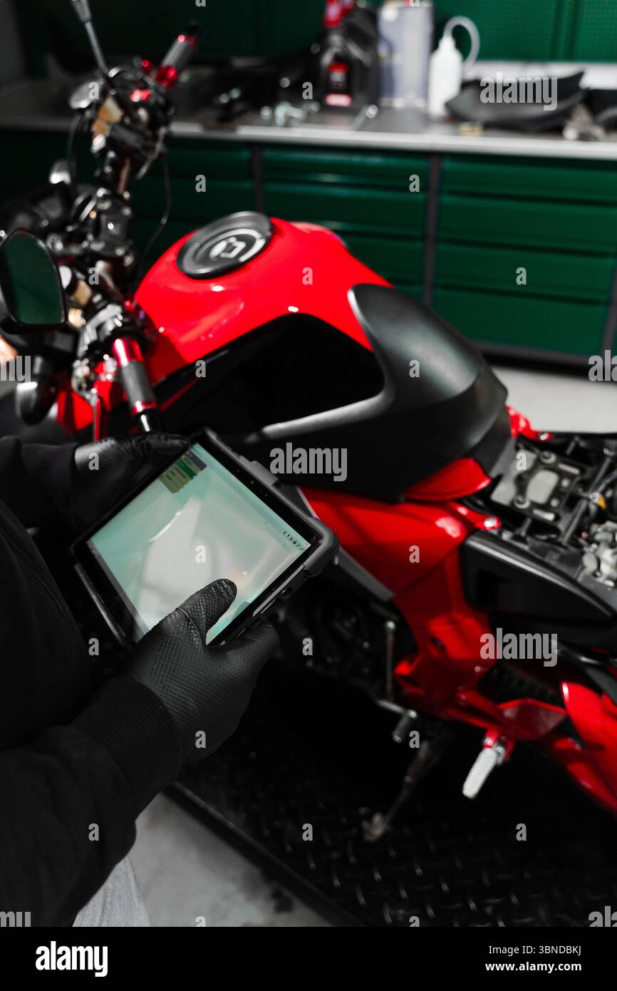 Motorcycle Scanning Mechanic performing system diagnostics via tablet. Motorcycle system ...