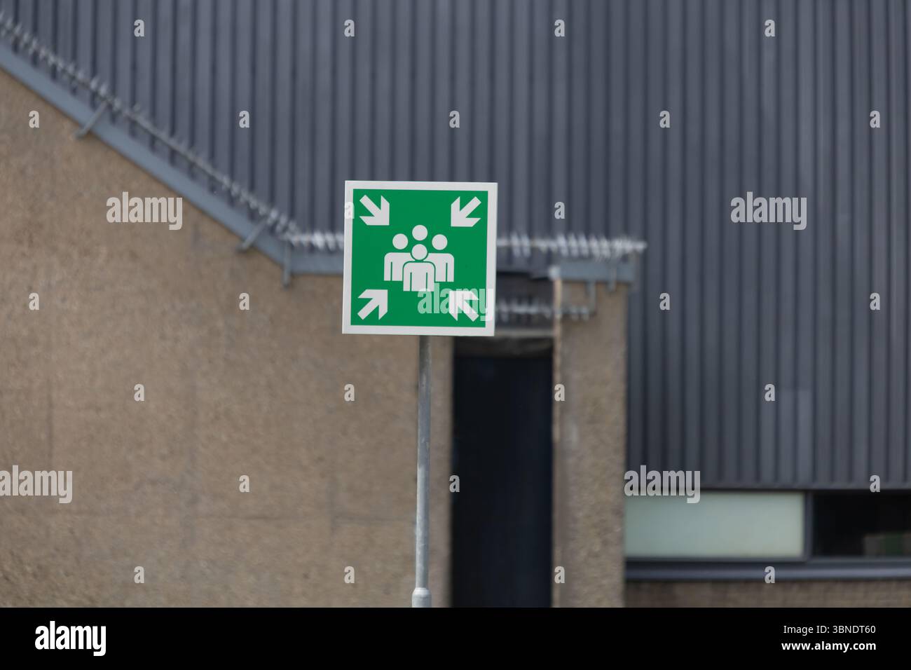 A clear green sign indicates an emergency assembly point, a crucial ...