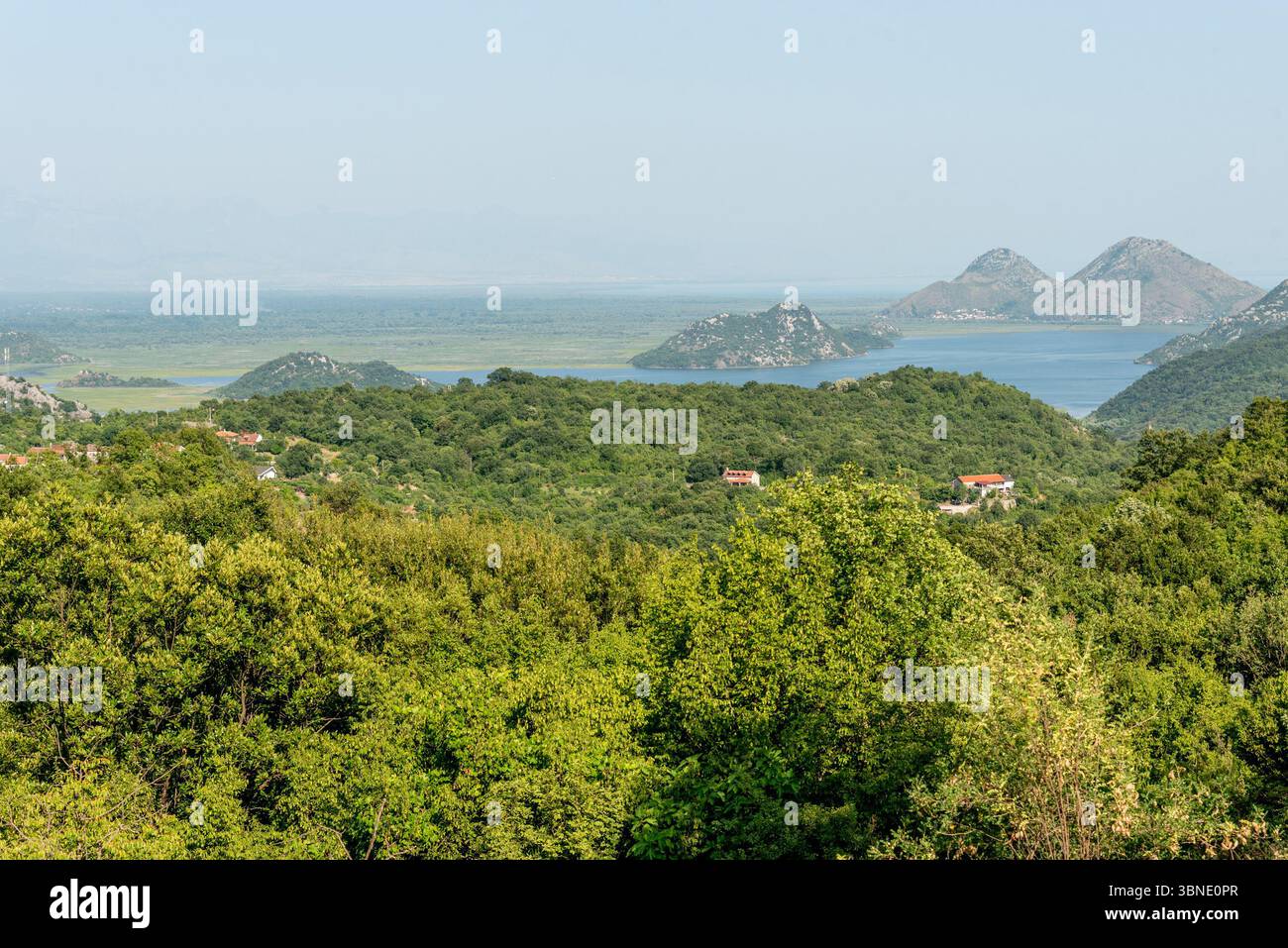 Landscape of blue deep lake in light of the sun in daytime, clouds in sky Skadar lake Montenegro Stock Photo