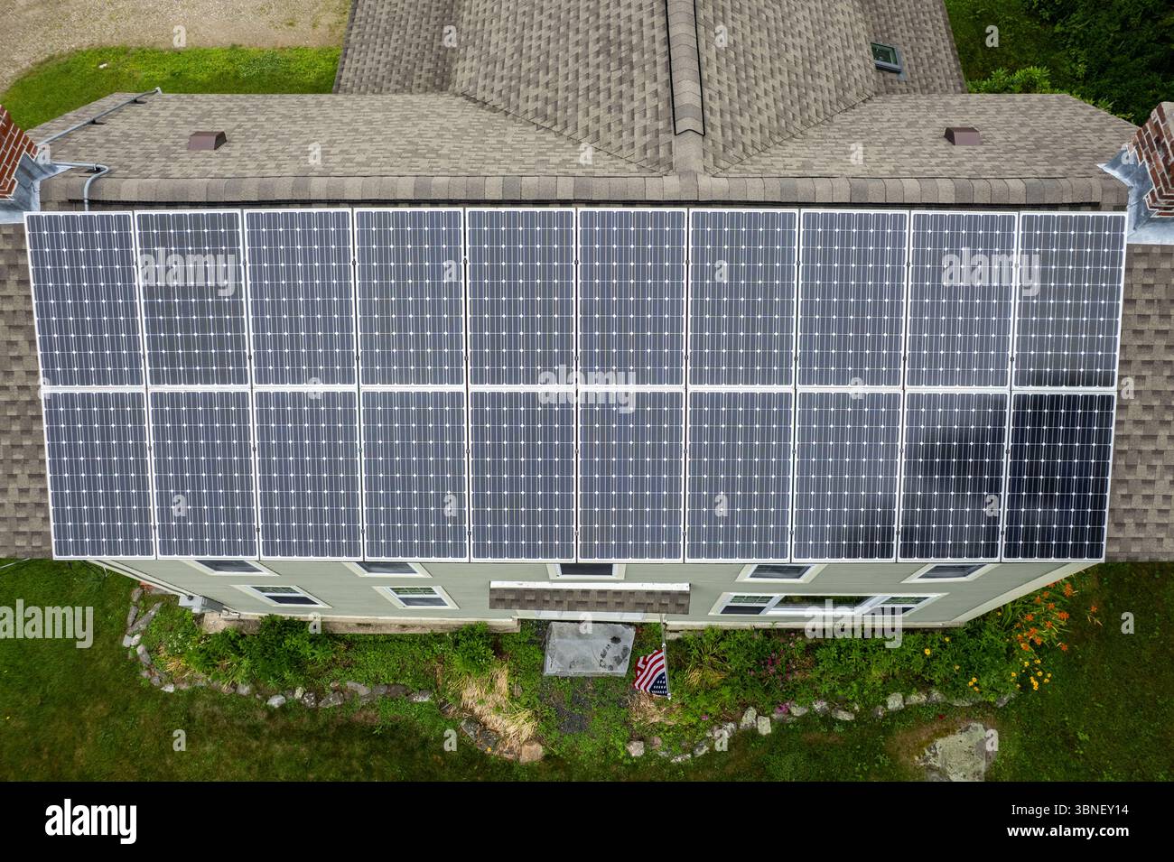 Wide-angle shot of a large rooftop solar array on a suburban home ...