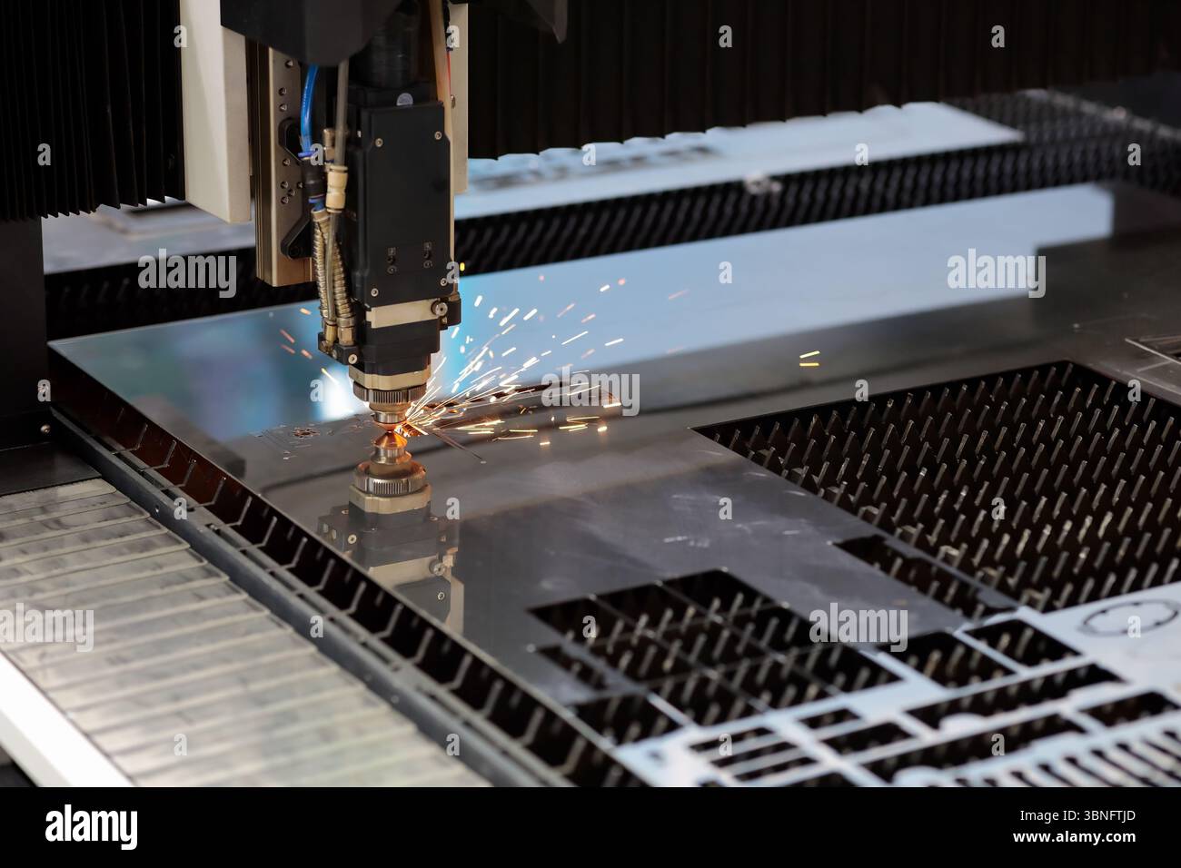 Sheet metal cutting process by CNC laser cutting machine. Selective focus. Stock Photo