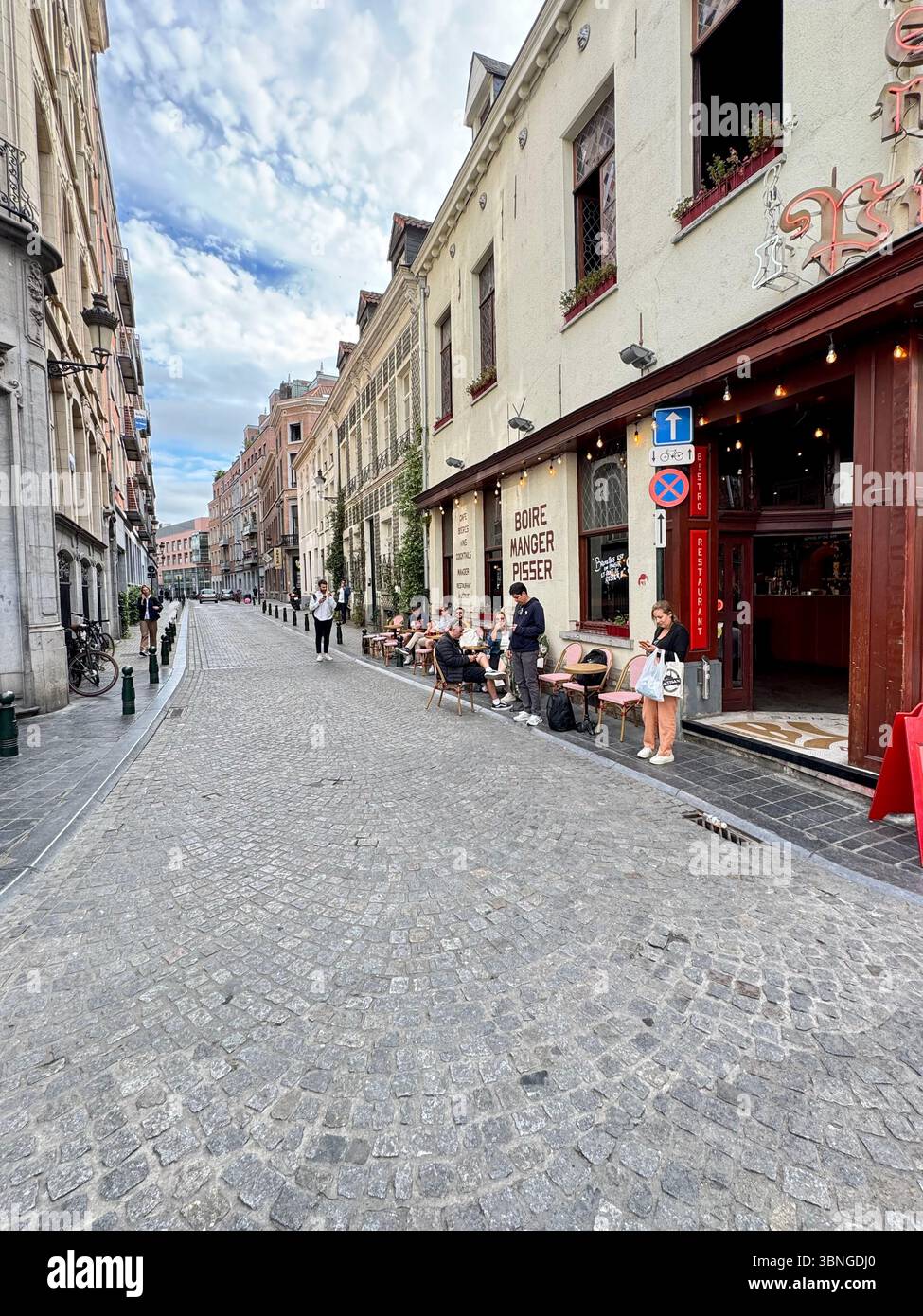 Charming cobblestone street with outdoor café seating and historic façades in Brussels, Belgium. - Smartphone Captured Stock Image