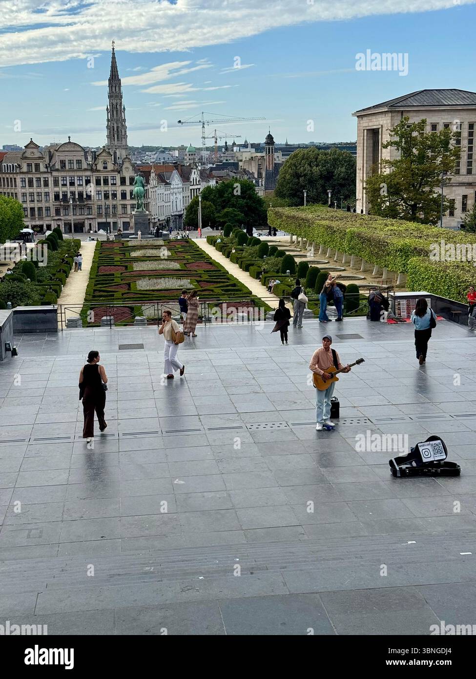 Musician busking at Mont des Arts overlooking formal gardens and Brussels skyline, Belgium. - Smartphone Captured Stock Image
