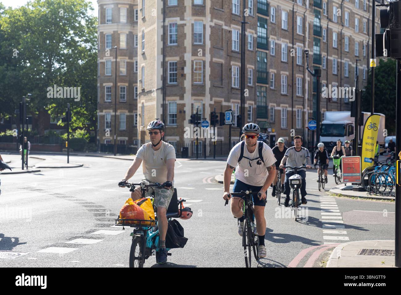 London, UK, 7 May 2025, Two Male Cyclists Ride Down a City Street Stock ...