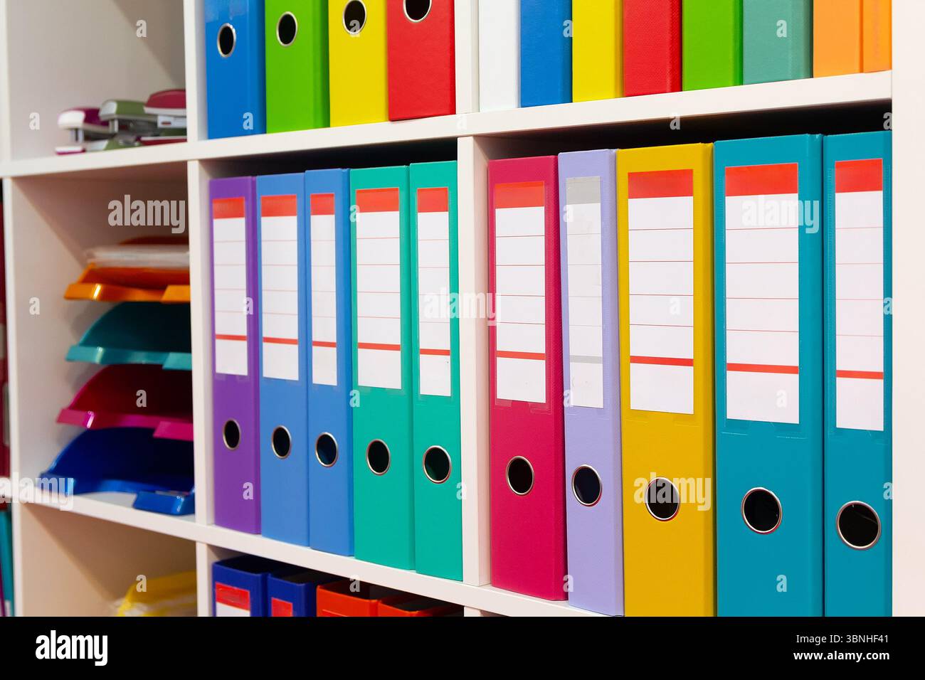 Colorful folders on a shelf in a modern office space. Busssines Stock Photo