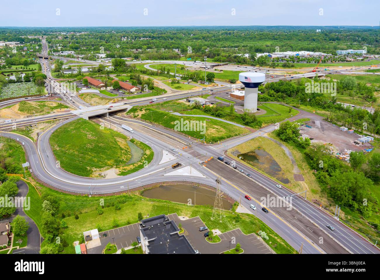 Multilane highway interchange with curved ramps, concrete bridges, water tower road infrastructure connects multiple directions in Bucks County, Pennsylvania Stock Photo