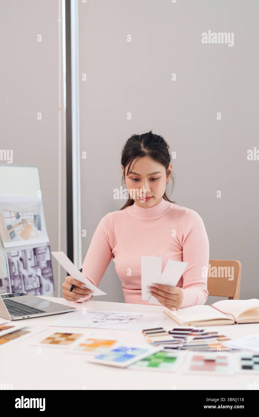 Young Asian woman UI designer working on a website design project ...