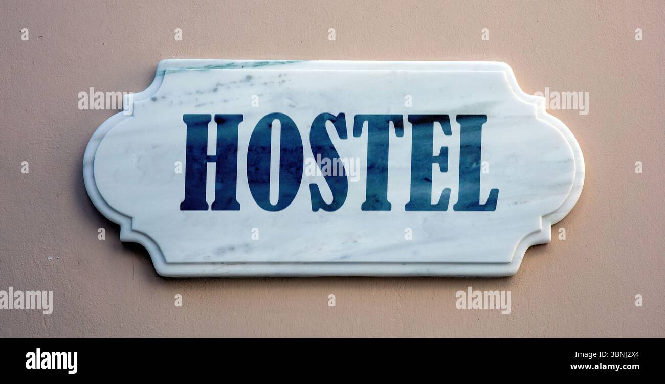 HOSTEL text marble sign on grey brown wall Stock Photo