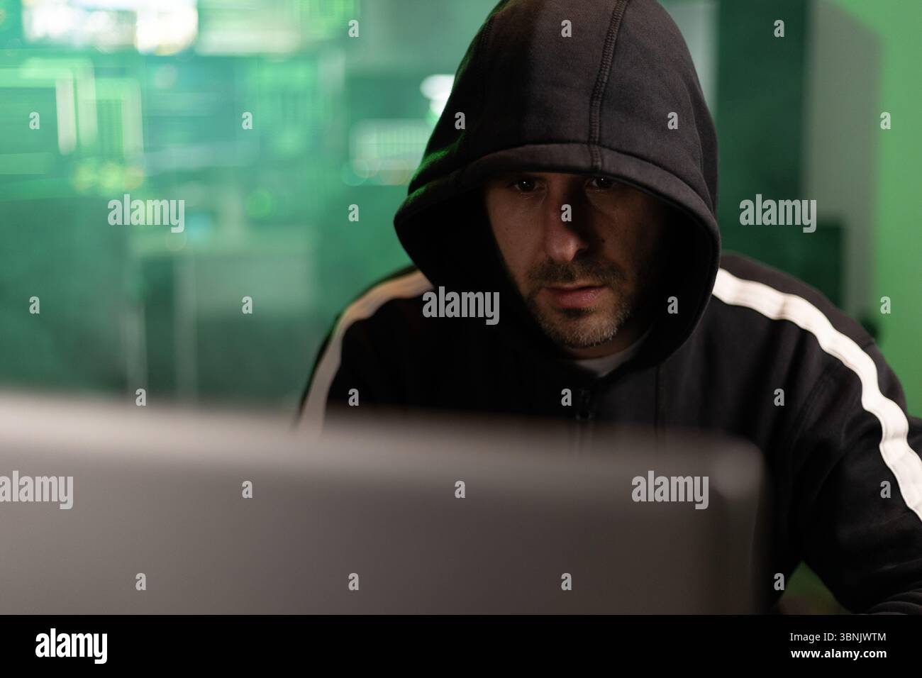 Hacker breaking into a secure network in a dark room Stock Photo