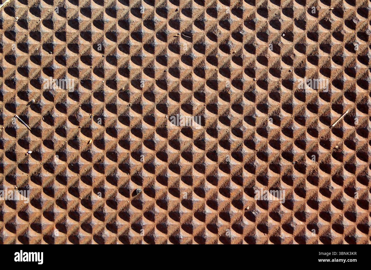 Raised diamond-shaped facets repeating pattern brown abstract textured background Stock Photo