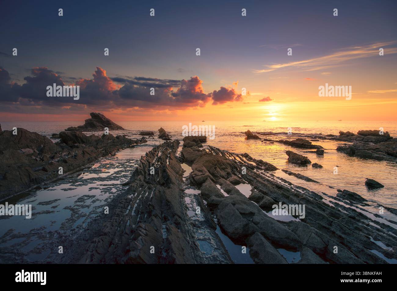 Jagged rocks in the sea at sunset in Romito, Antignano. Livorno, Tuscany coast, Italy, Europe Stock Photo