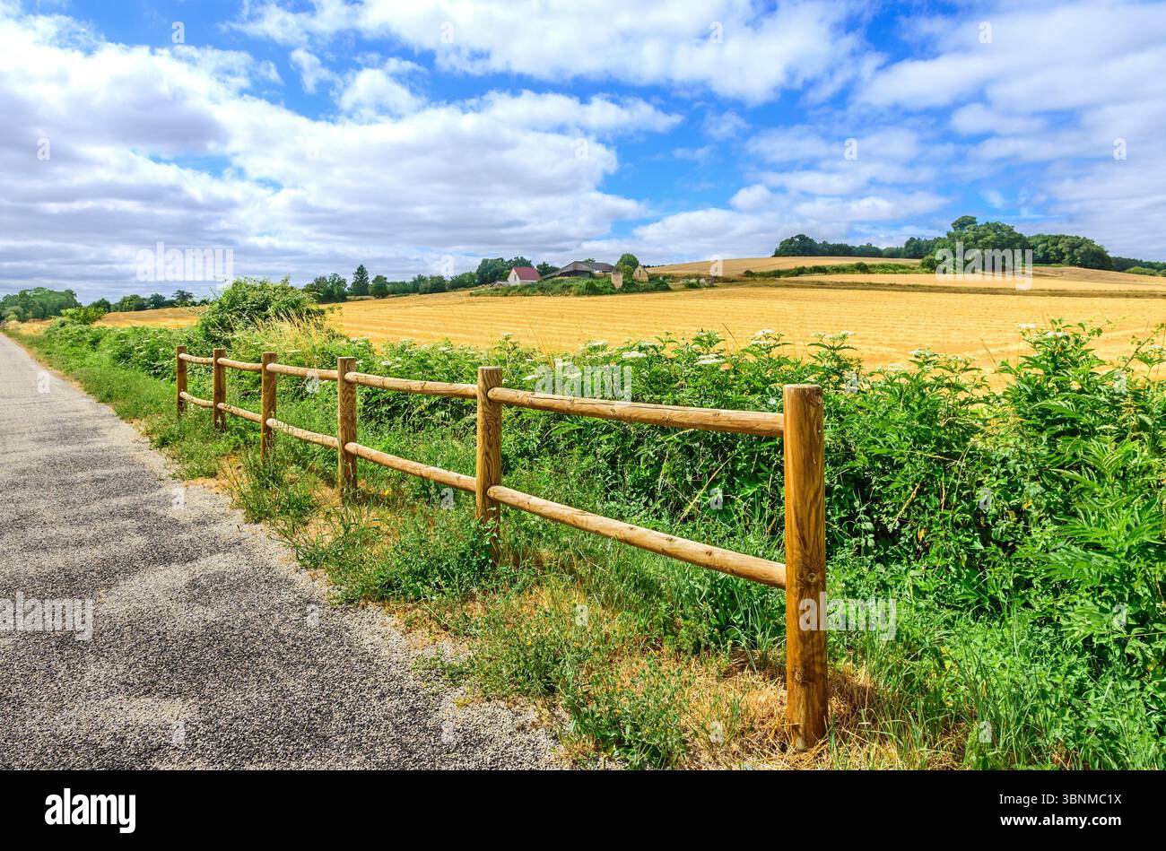 Wooden fence barrier along part of 'voie verte' cycle way as protection from drop into hidden underpass - central France. Stock Photo