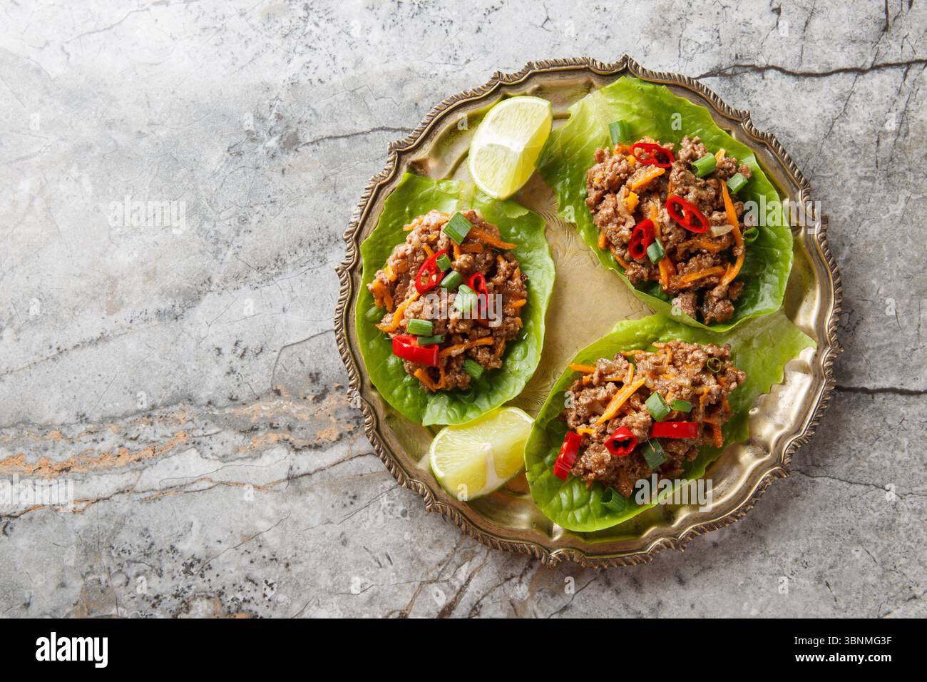 Asian Ground Beef Lettuce Wraps cups with vegetables close-up on the plate on table. Horizontal top view from above Stock Photo