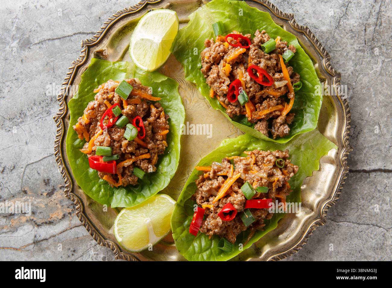 Ground Beef Lettuce Wraps with vegetables close-up on the plate on table. Horizontal top view from above Stock Photo