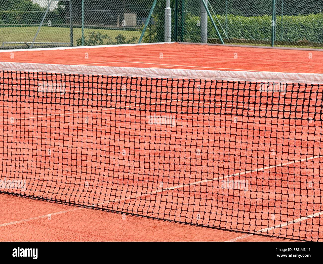 Close up view of part of the net on a clay tennis court. No people. - Smartphone Captured Stock Image