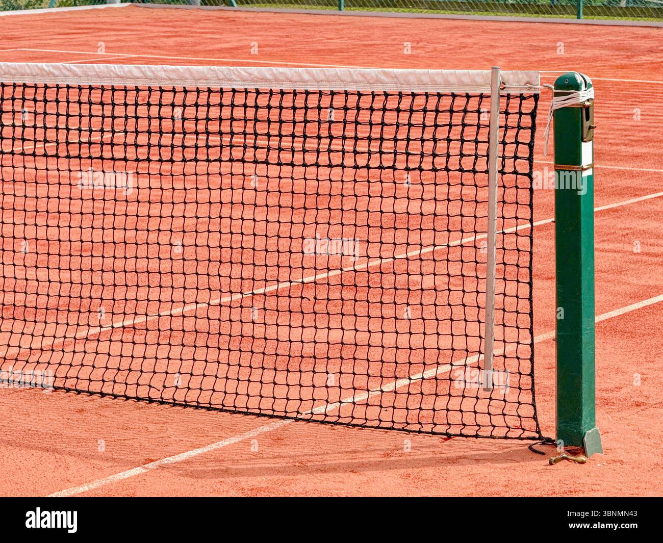 Close up view of part of the net on a clay tennis court. No people. - Smartphone Captured Stock Image