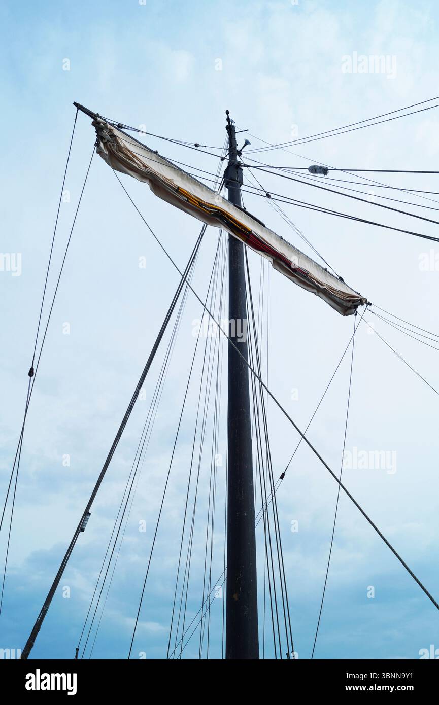 The mast of a ship with a furled sail, ropes, cordage, cloudy sky Stock ...