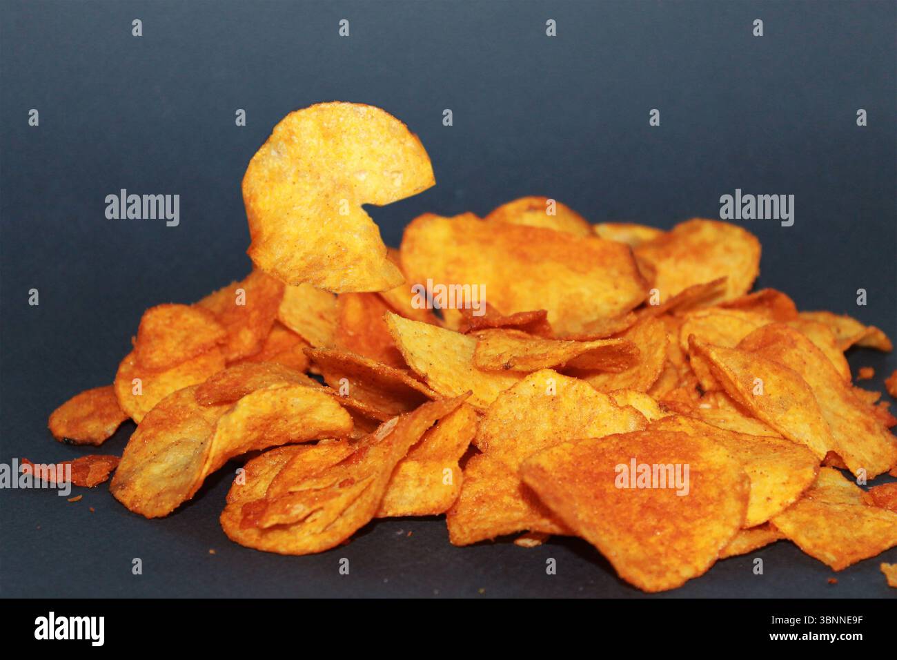 Chips with paprika on a dark background. Stock Photo