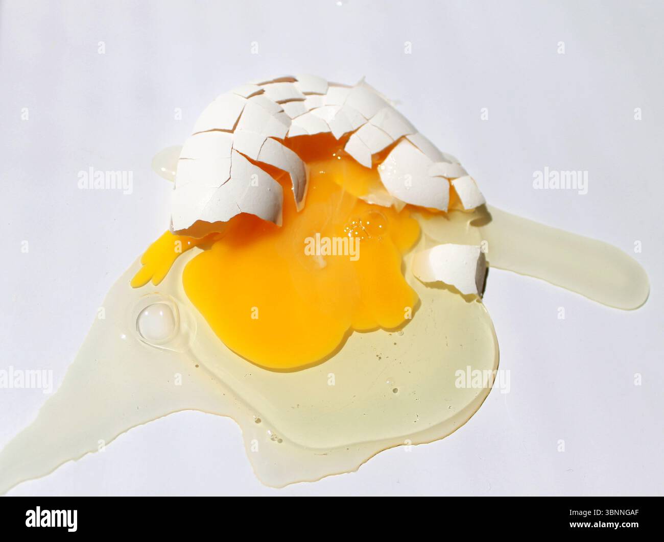 Broken chicken egg on white background. Top view. Stock Photo