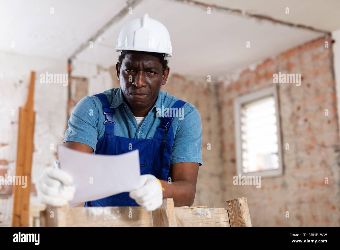 Man construction worker with document inside apartment Stock Photo