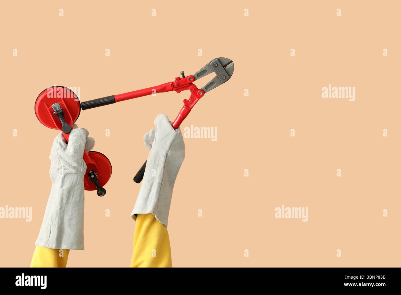 Female worker with tools on beige background Stock Photo