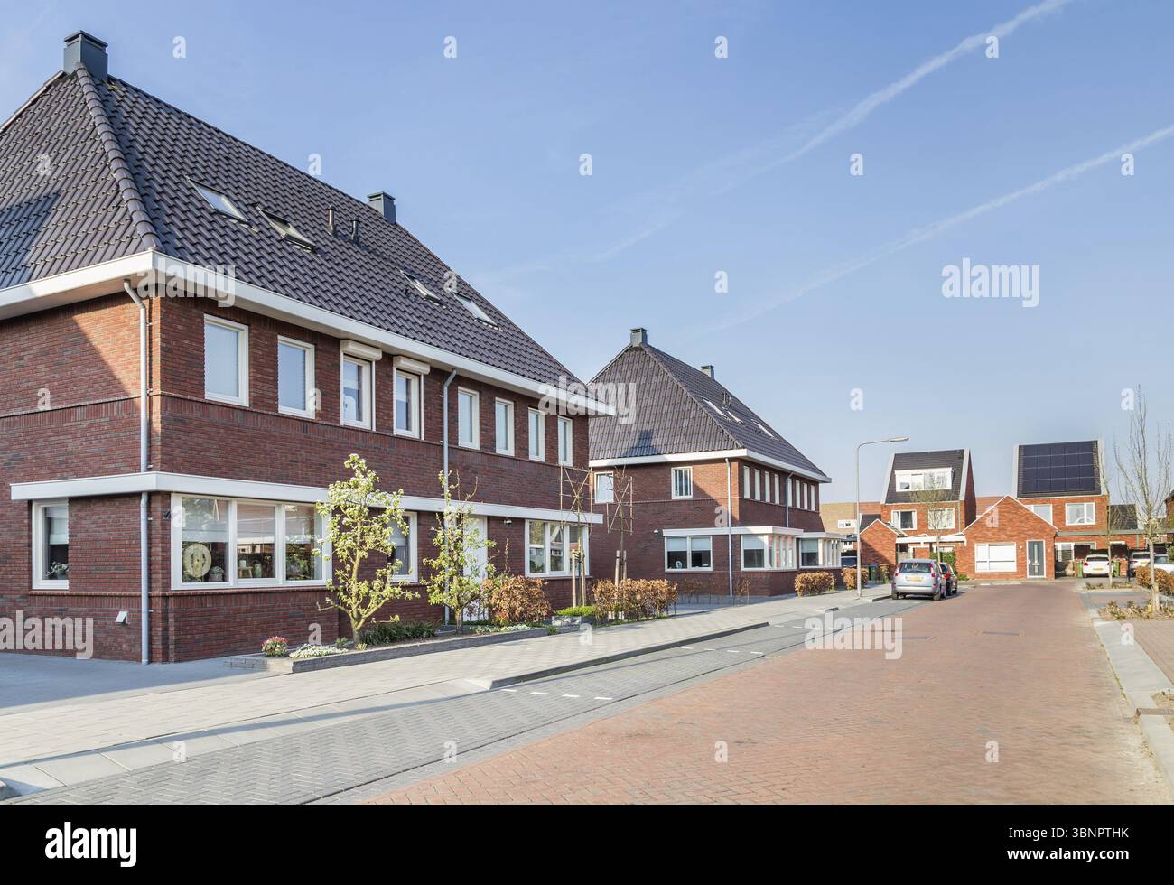 Newly built houses in a family friendly modern suburban neighborhood with solar panels en electric car charger in Veenendaal in the Netherlands Stock Photo
