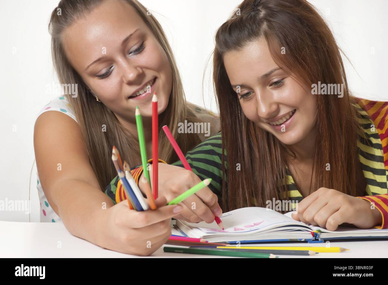 Two teenage girls smiling and painted in the book Stock Photo - Alamy