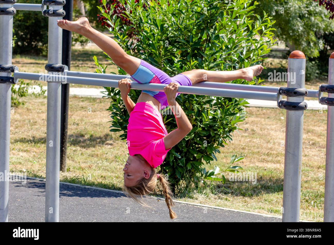 Child performing an upside-down split on a horizontal bar Stock Photo ...