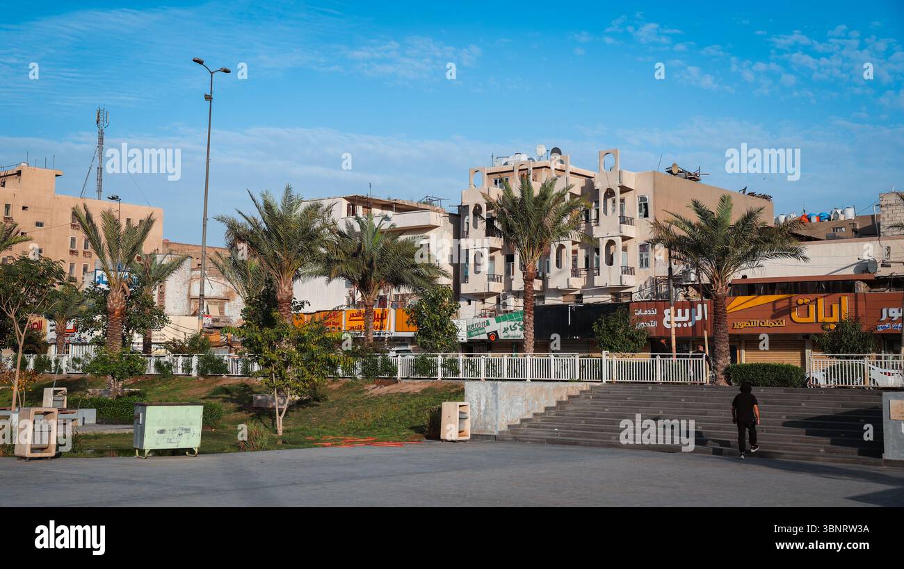 People enjoy an afternoon in Baghdad as palm trees sway and nearby ...