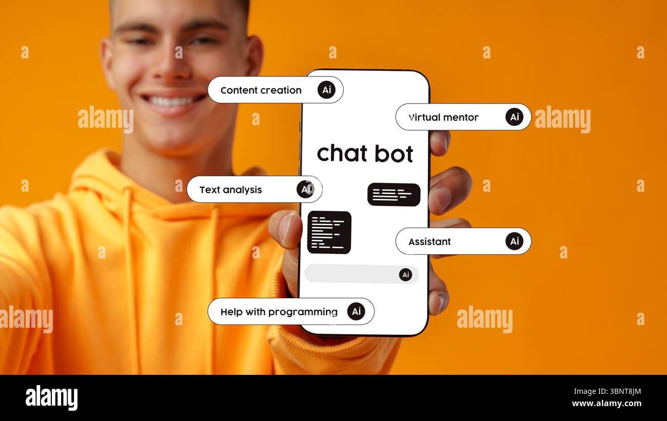 Young man showcasing a chatbot interface on a smartphone against a bright orange background Stock Photo